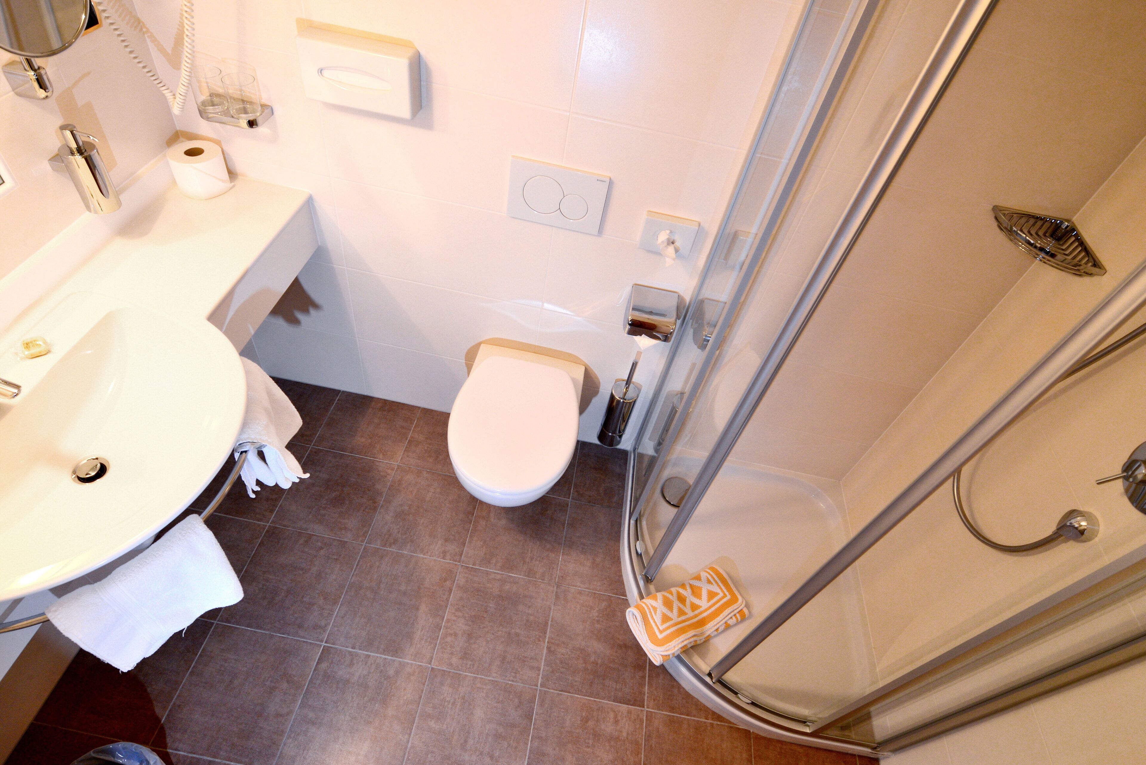 A bathroom with a sink, toilet, and shower.
