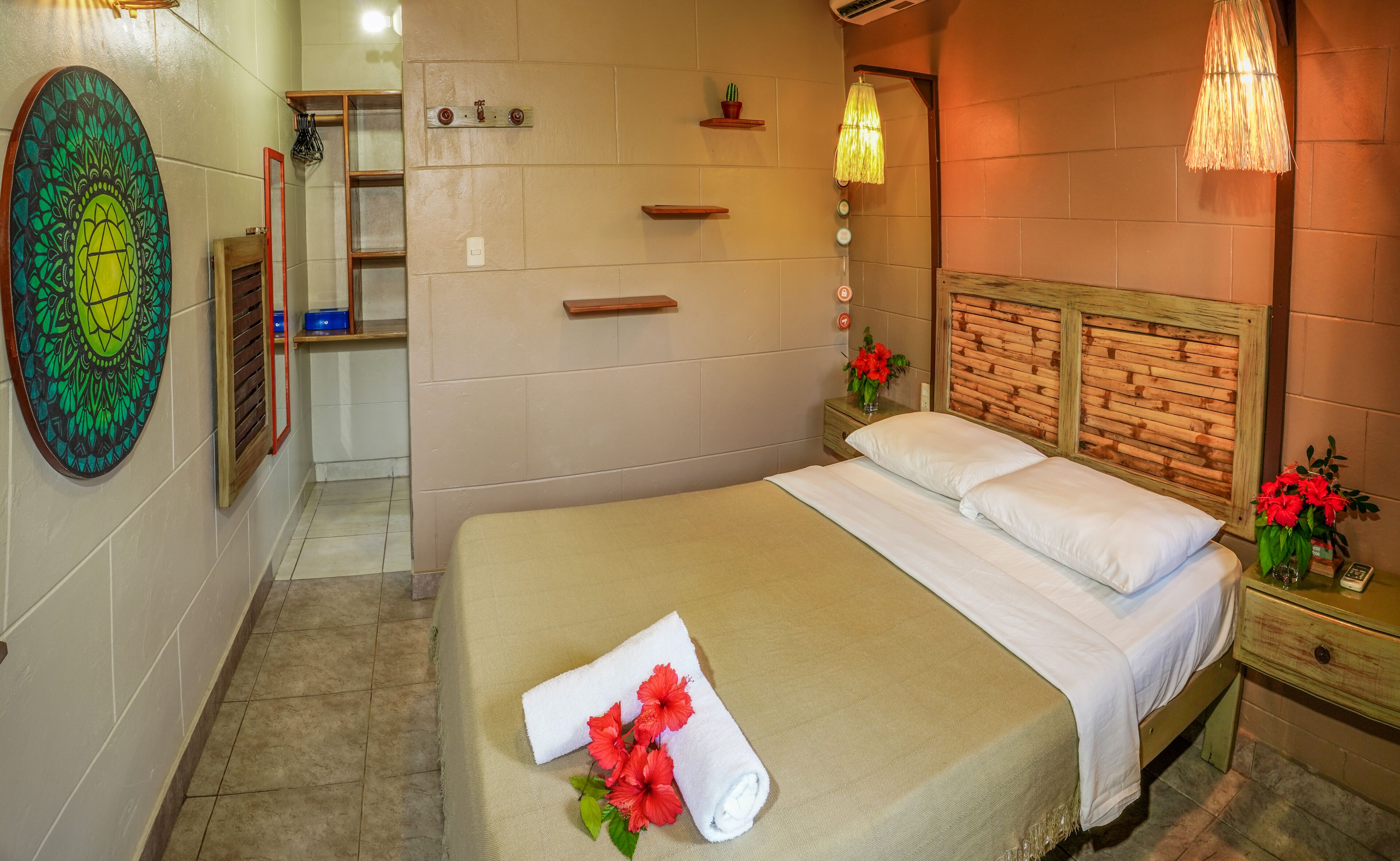 Un dormitorio ordenado con cama, mesita de noche y estante en la pared.