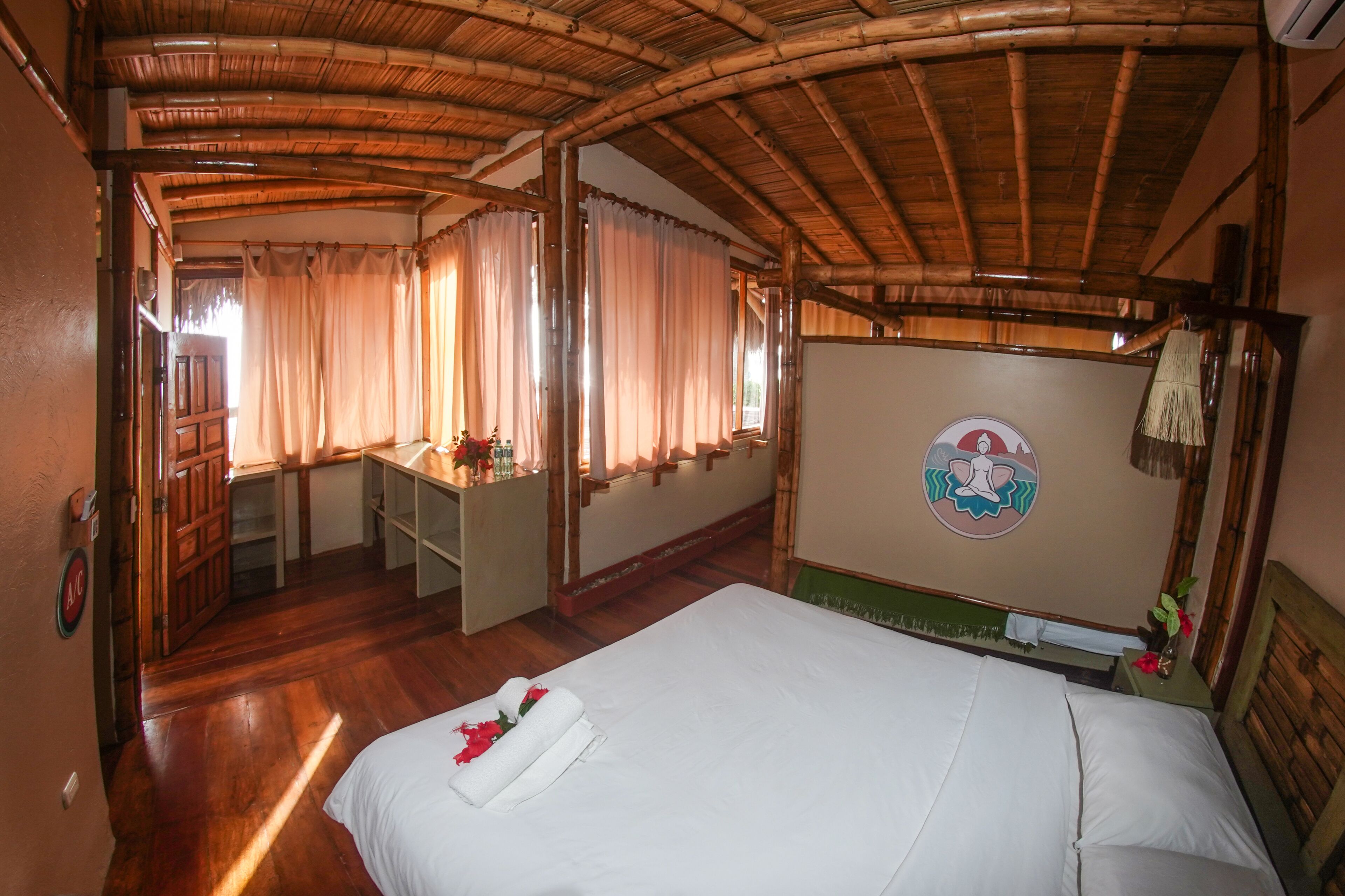 Una habitación con cama, escritorio y espejo.