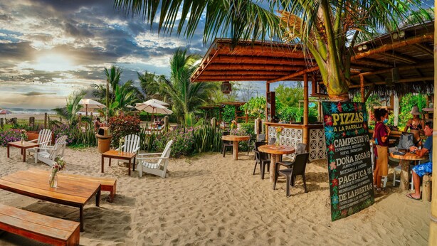 Un restaurante frente a la playa con terraza, un menú y vistas al mar.