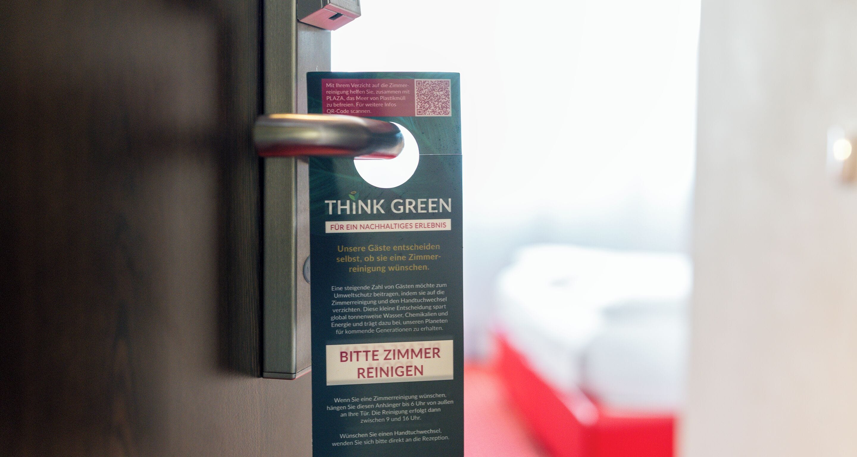 Eine Tür mit einem Schild, auf dem steht: "THINK GREEN" und "BITTE ZIMMER REINIGEN".