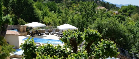 Una piscina al aire libre de temporada, sombrillas