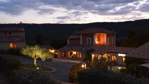 A residential area with multiple houses, each with a tiled roof and a well-lit entrance. - Hôtel Le Colombier (Moustiers-Sainte-Marie)