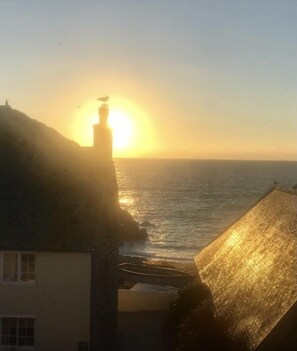 A sunset over the sea with buildings in the foreground.