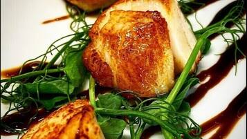 A plate with grilled chicken, greens, and a drizzle of sauce.