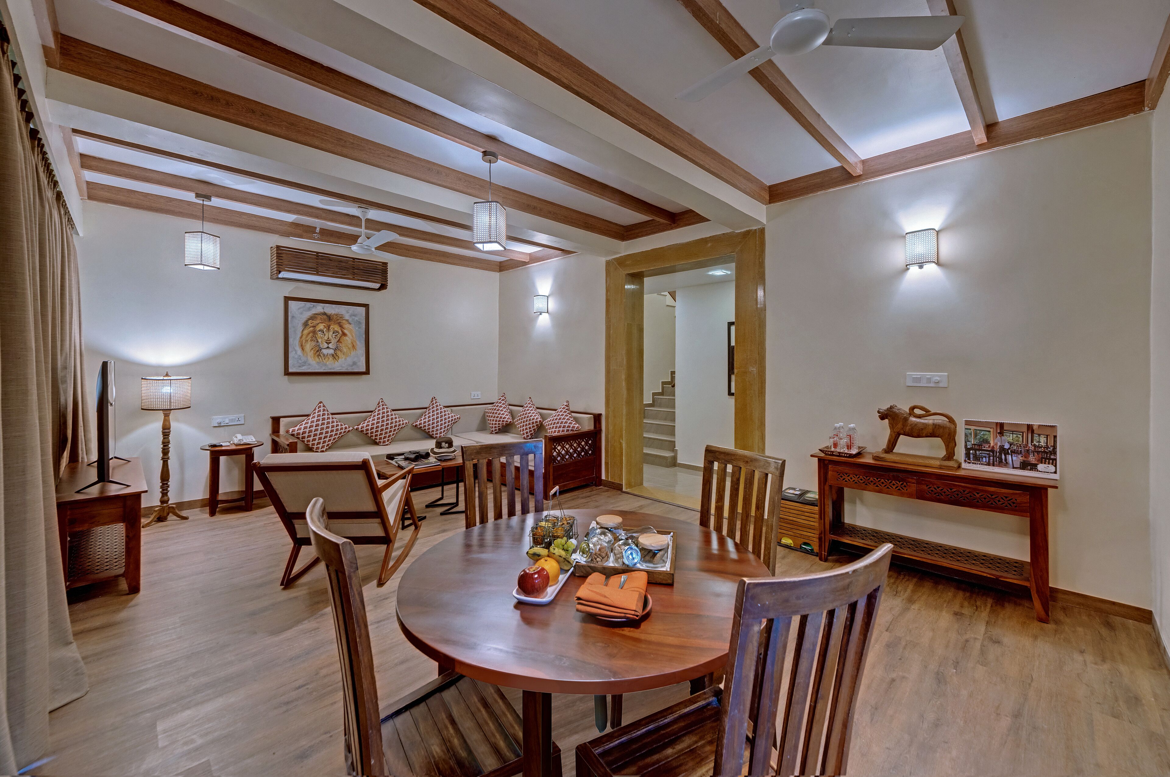 A dining area with a round wooden table, chairs, and a decorative centerpiece.