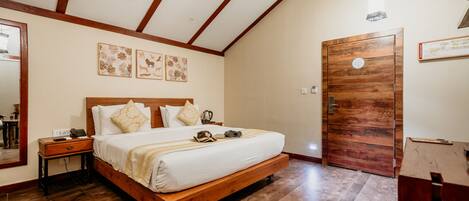 A bedroom with a wooden bed, a nightstand, a bedside table, and a wooden door.