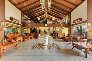 A spacious lobby with a high wooden ceiling, a central decorative pillar, and a staircase leading to an upper level. - The Fern Gir Forest Resort Sasan Gir, Series by Marriott (Mendarda)