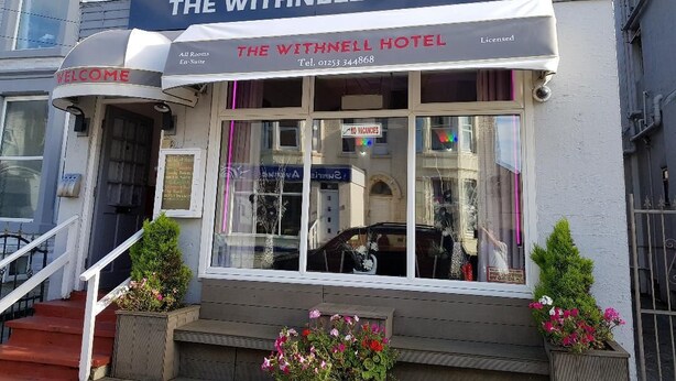 Hotel Withnell con un letrero, un cartel de bienvenida y un número de teléfono.