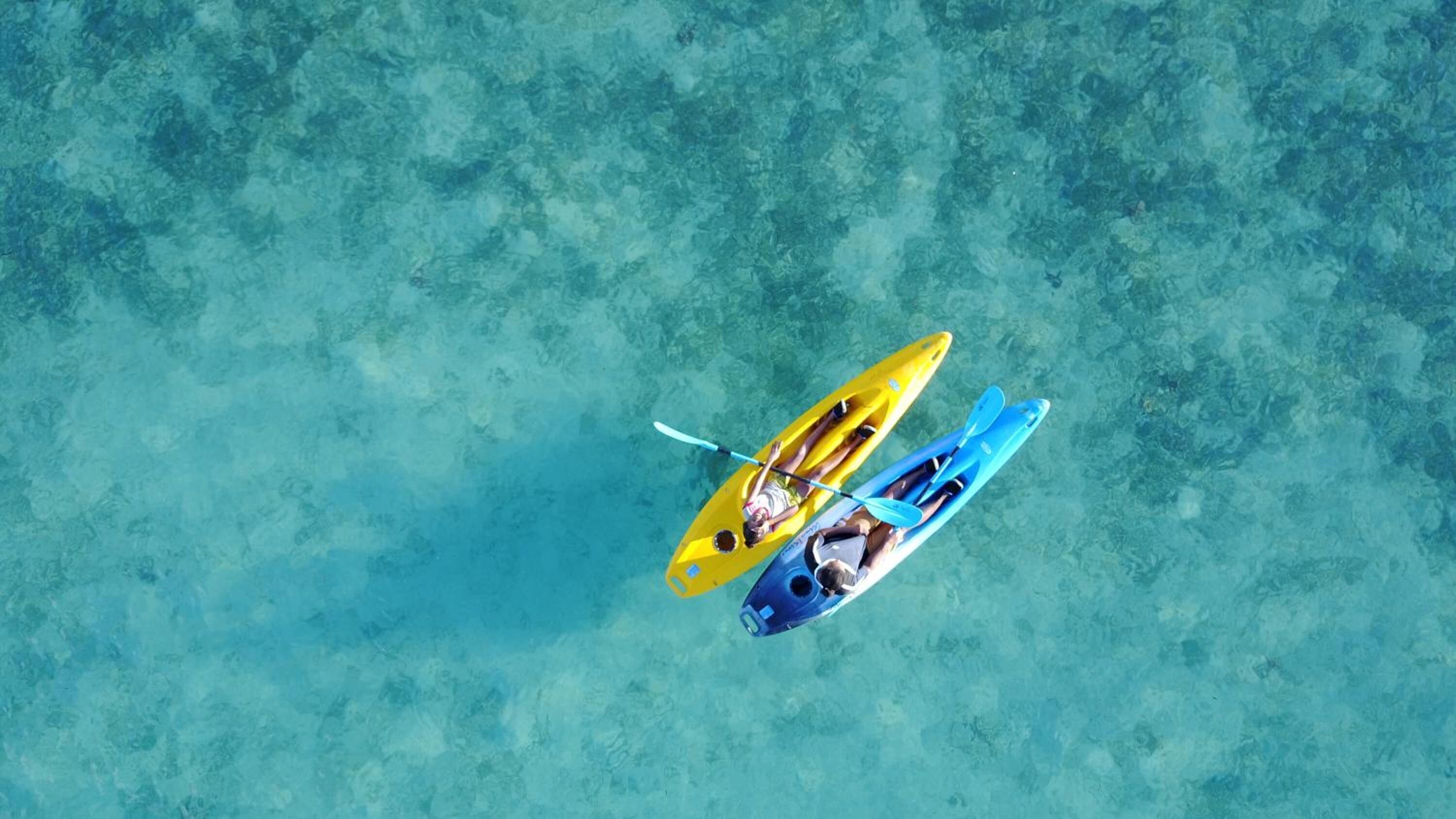 Dos kayaks sobre una superficie de agua turquesa.