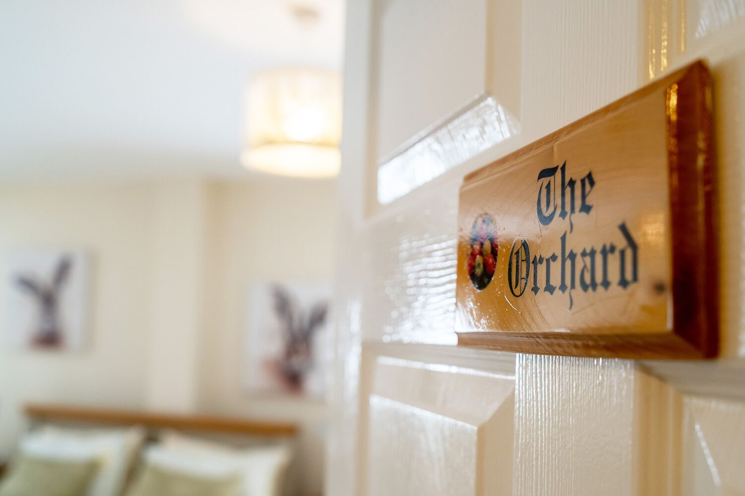 Un letrero de madera con el texto 'The Orchard' en una pared.