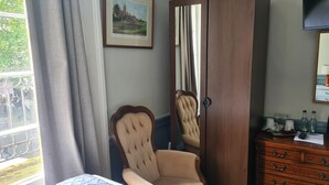 A room with a bed, a chair, a dresser, a mirror, and a framed picture on the wall. - Kings Boutique Hotel (London)