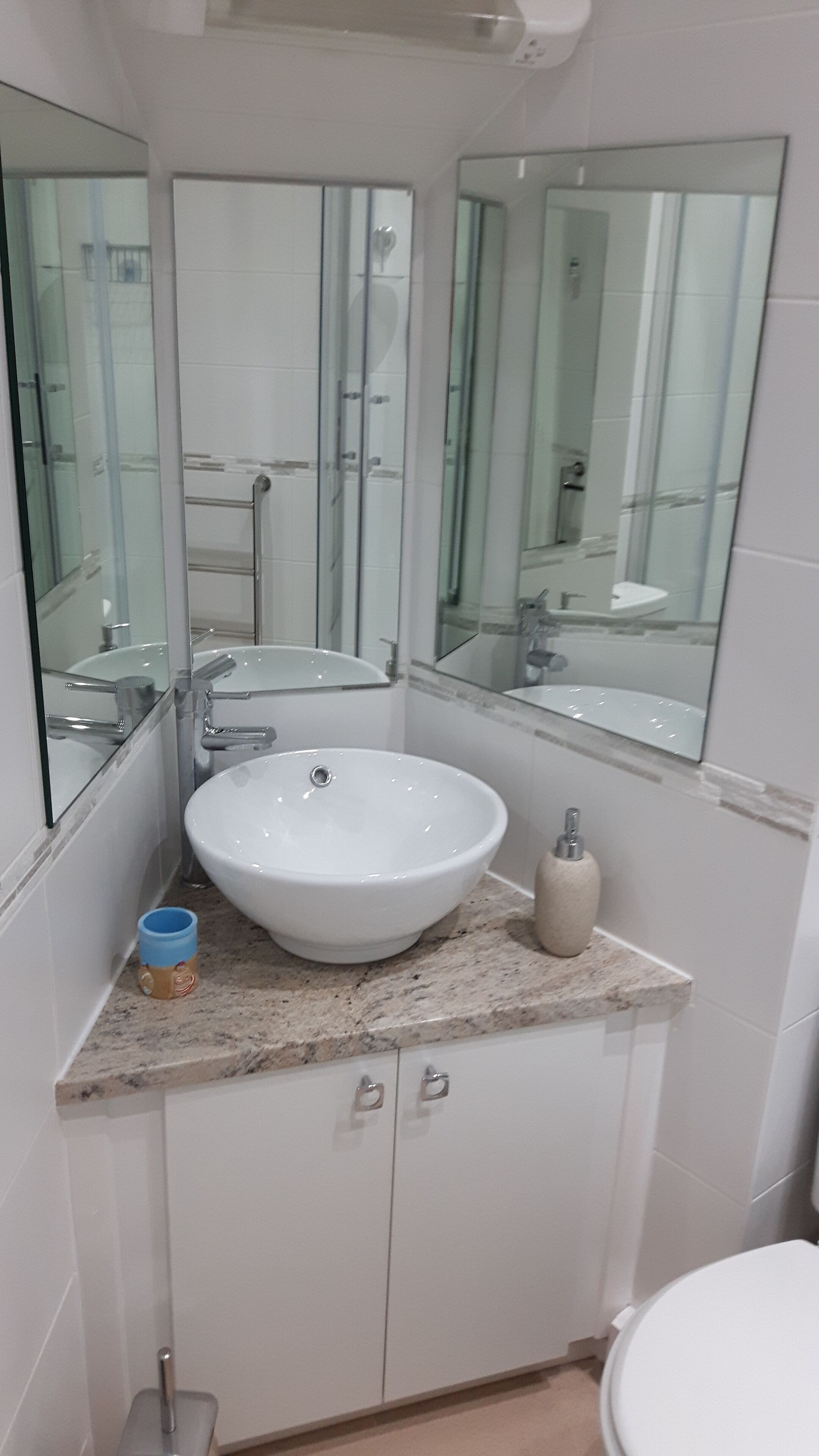 Ein Badezimmer mit Waschbecken, Spiegel und Toilette.