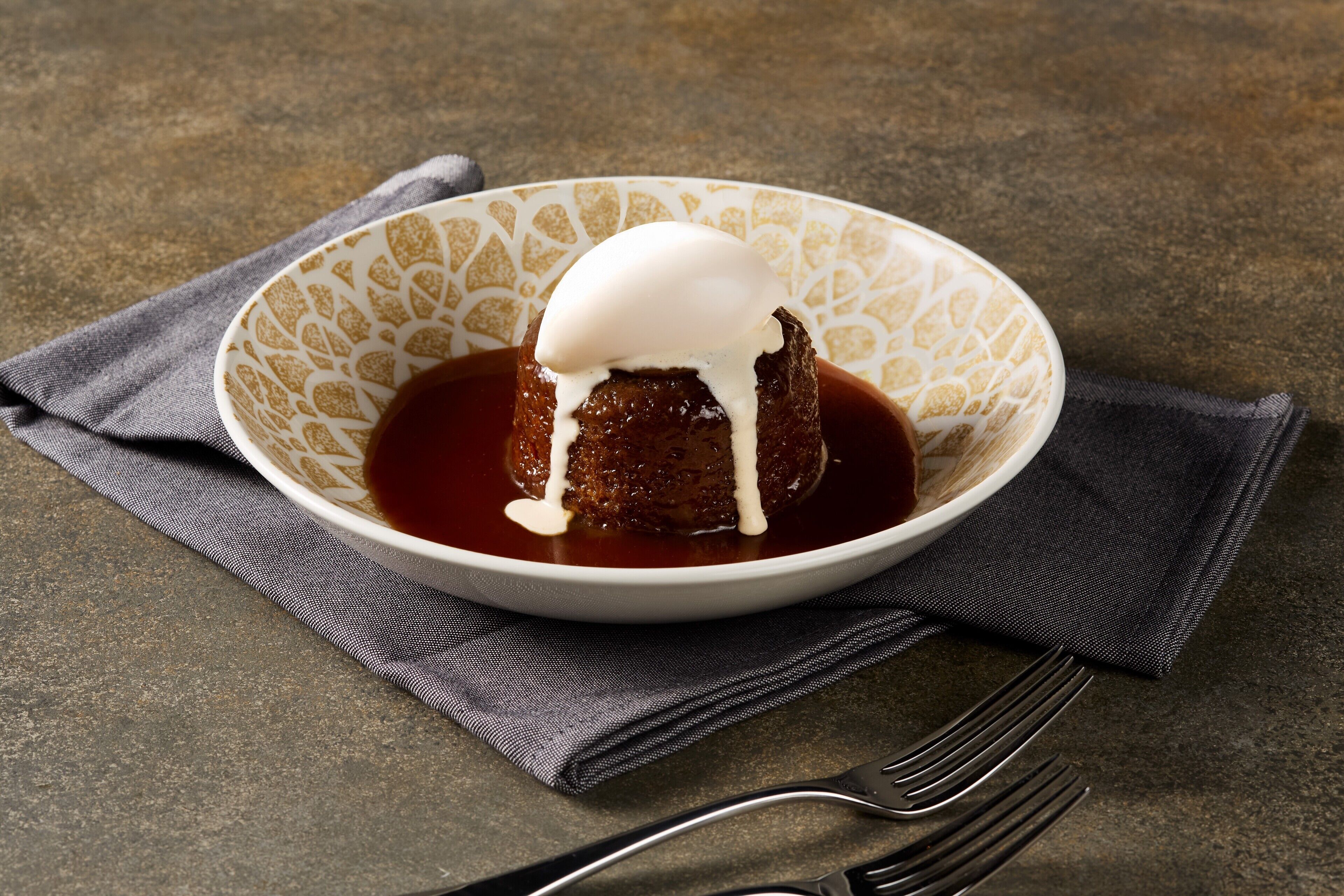 Un postre en un tazón con una servilleta y un tenedor al lado.