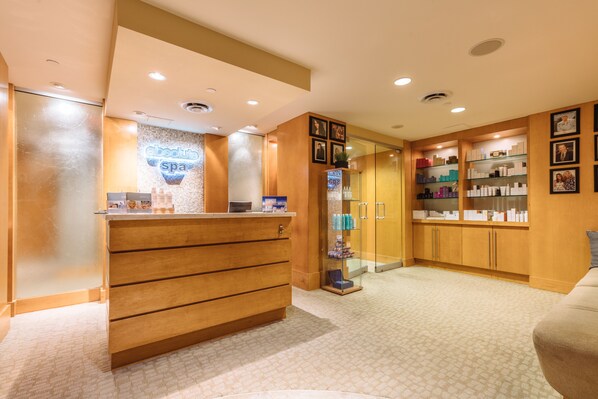 A reception area with a wooden counter, a glass display case, and a wall with framed pictures.
