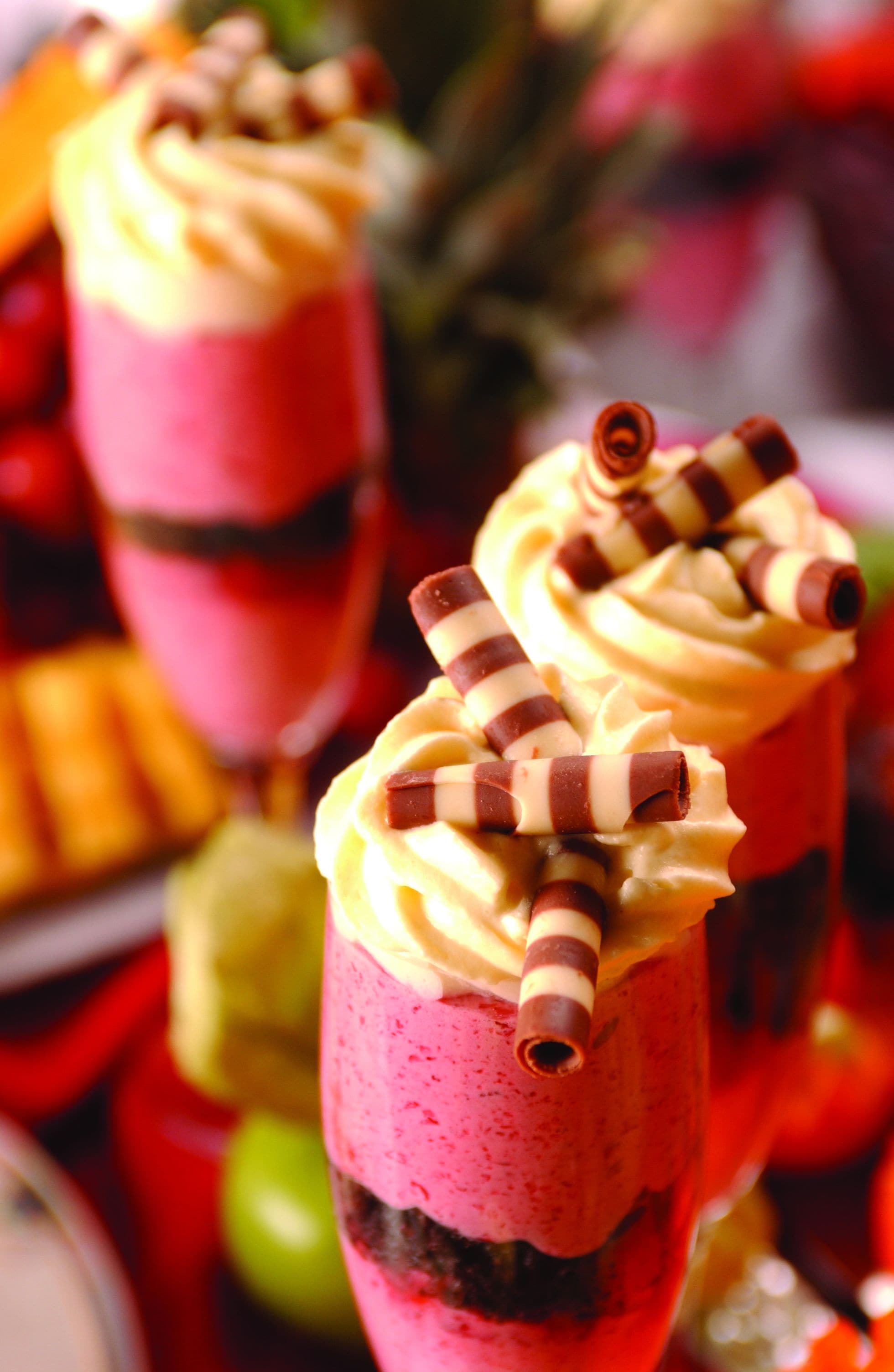 A dessert with a pink and yellow swirl, topped with chocolate sticks.