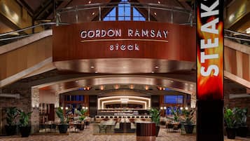 Un restaurant Gordon Ramsay Steak doté d’un bar, de tables et offrant une vue sur le paysage urbain.