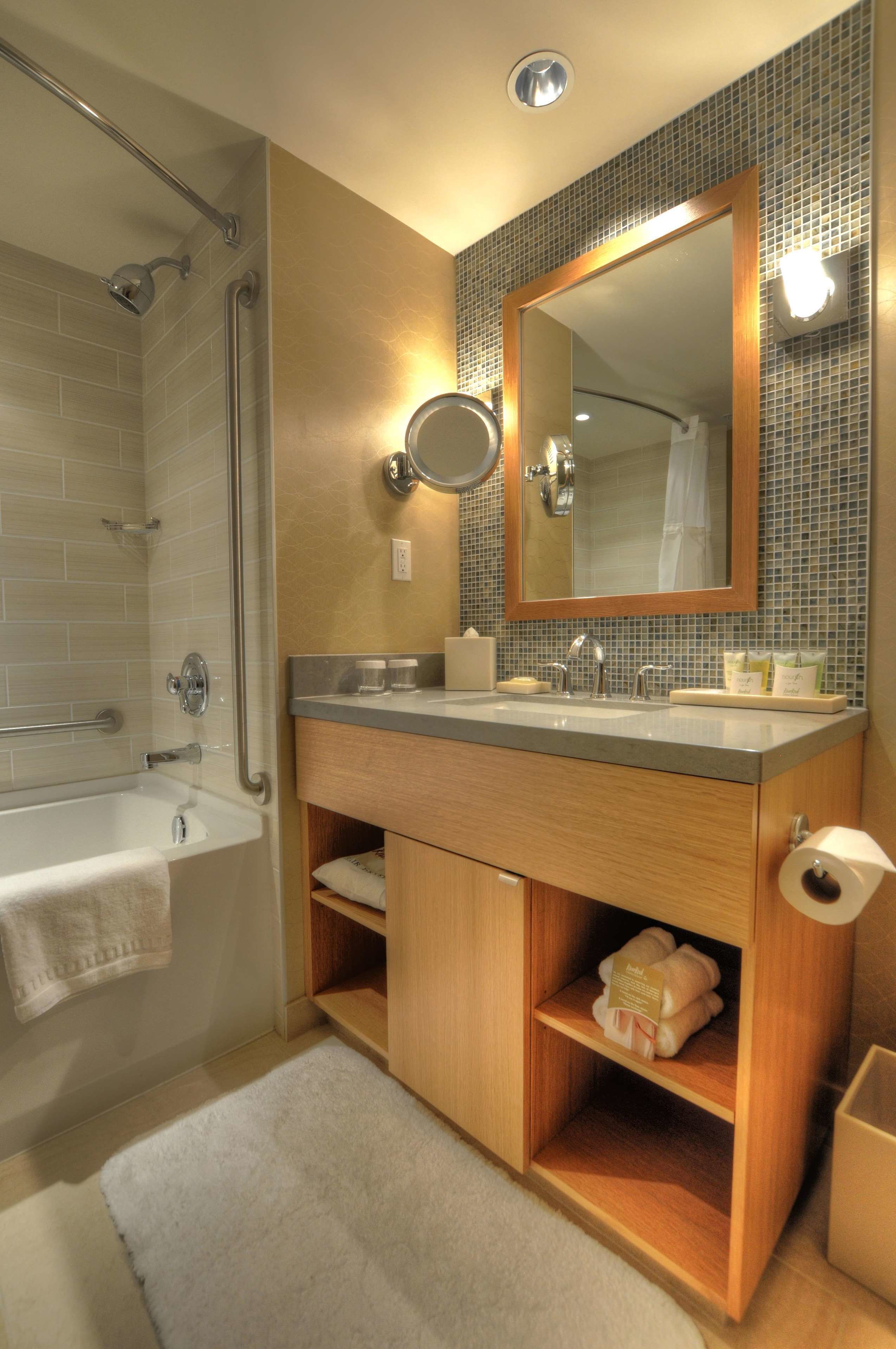 Un baño moderno con bañera, tocador con espejo y zona de ducha.