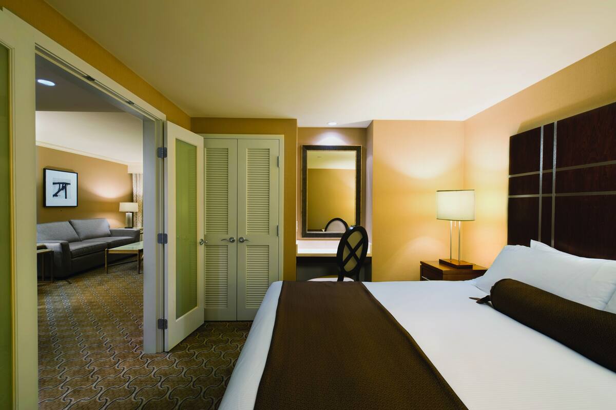 Een hotelkamer met een bed, een bureau, een stoel, een bank en een spiegel.