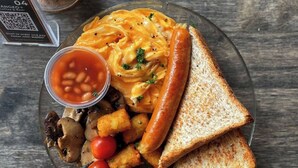 A plate with a sausage, toast, beans, mushrooms, and a sauce. - ibis budget Singapore Clarke Quay (Singapore)
