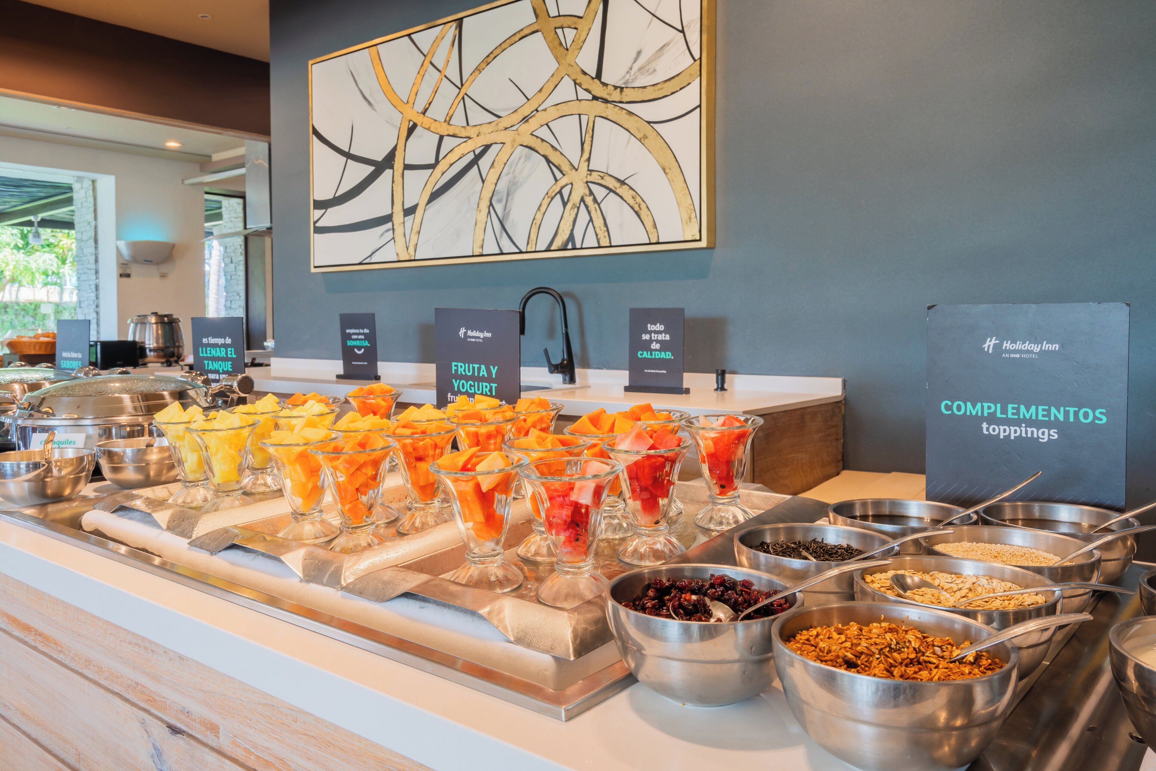 A buffet with various fruits, yogurt, and toppings.
