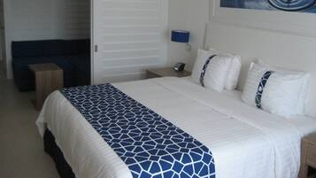 Une chambre d’hôtel avec un lit, une table de chevet, une lampe et un tableau au mur.