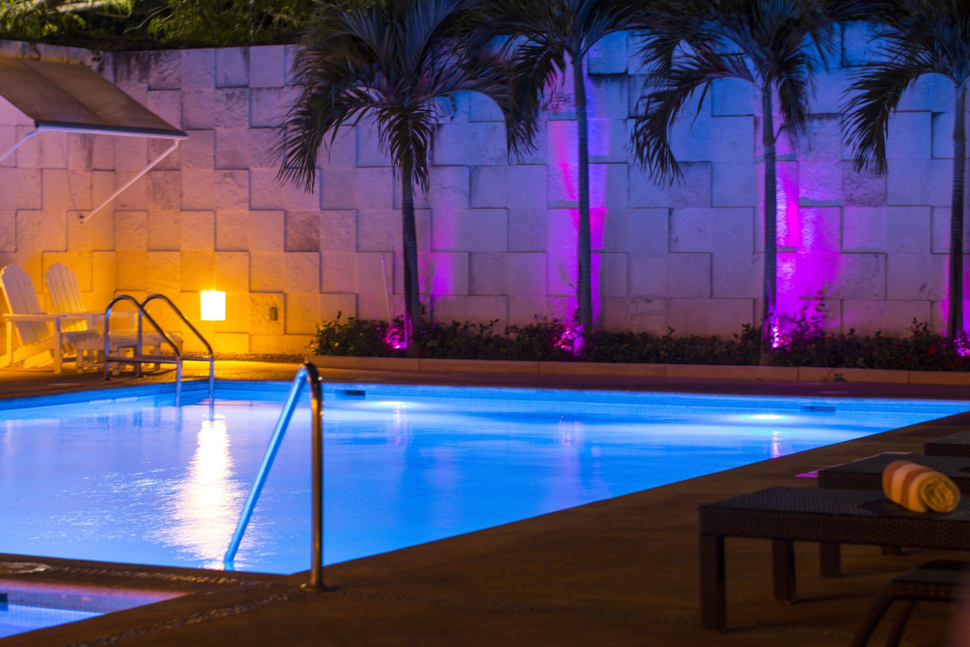 Una piscina al aire libre, sillones reclinables de piscina