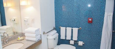 A bathroom with a sink, toilet, and a shower area.