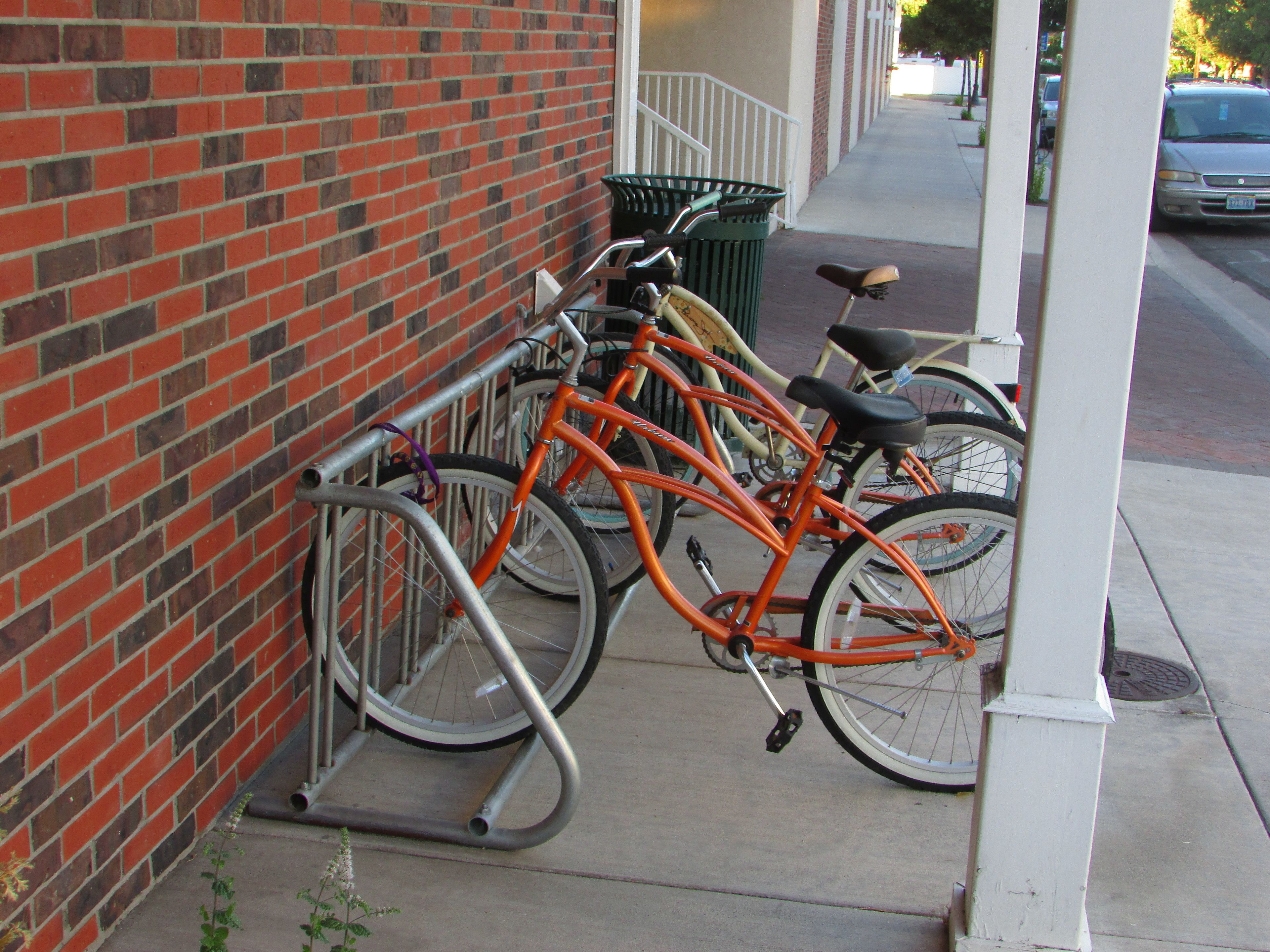 A brick building with a metal bike rack attached to the wall.