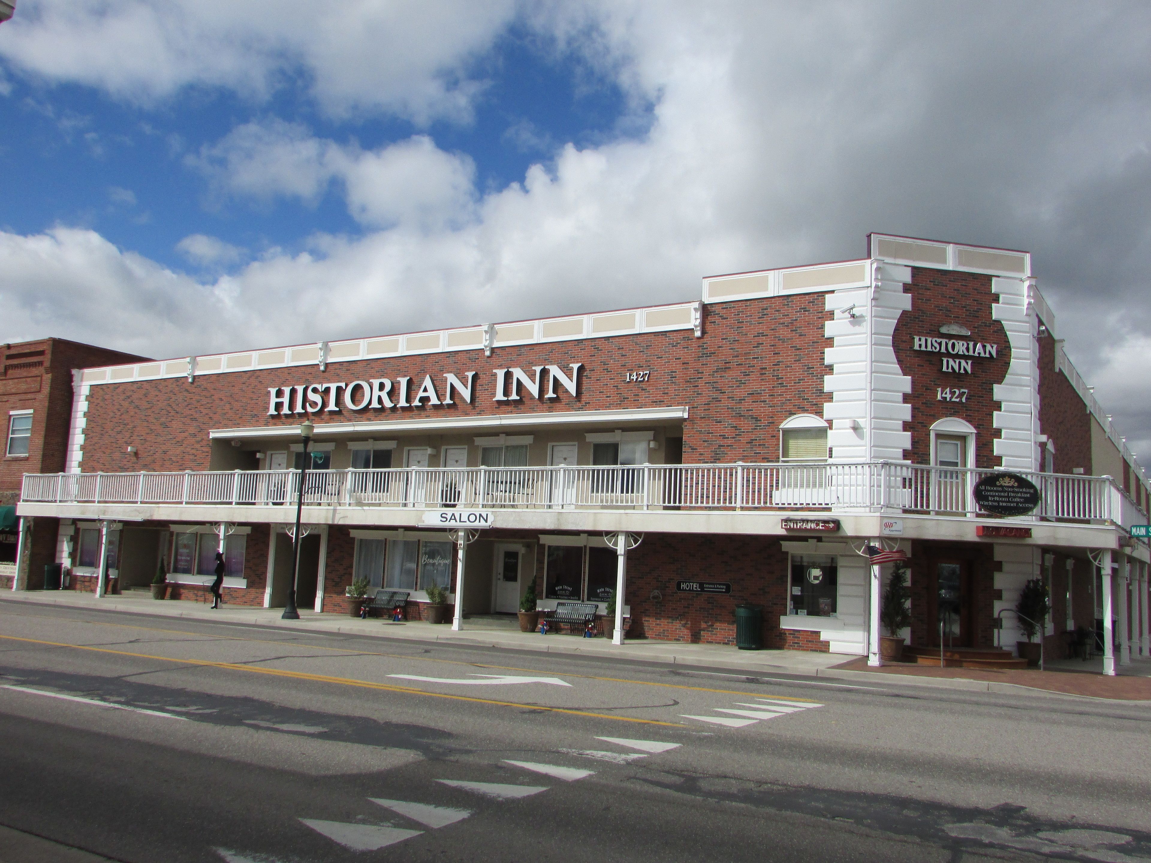 A brick building with a sign reading "Historian Inn" and a balcony with a railing.