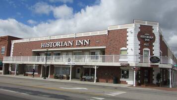 A brick building with a sign reading "Historian Inn" and a balcony with a railing.