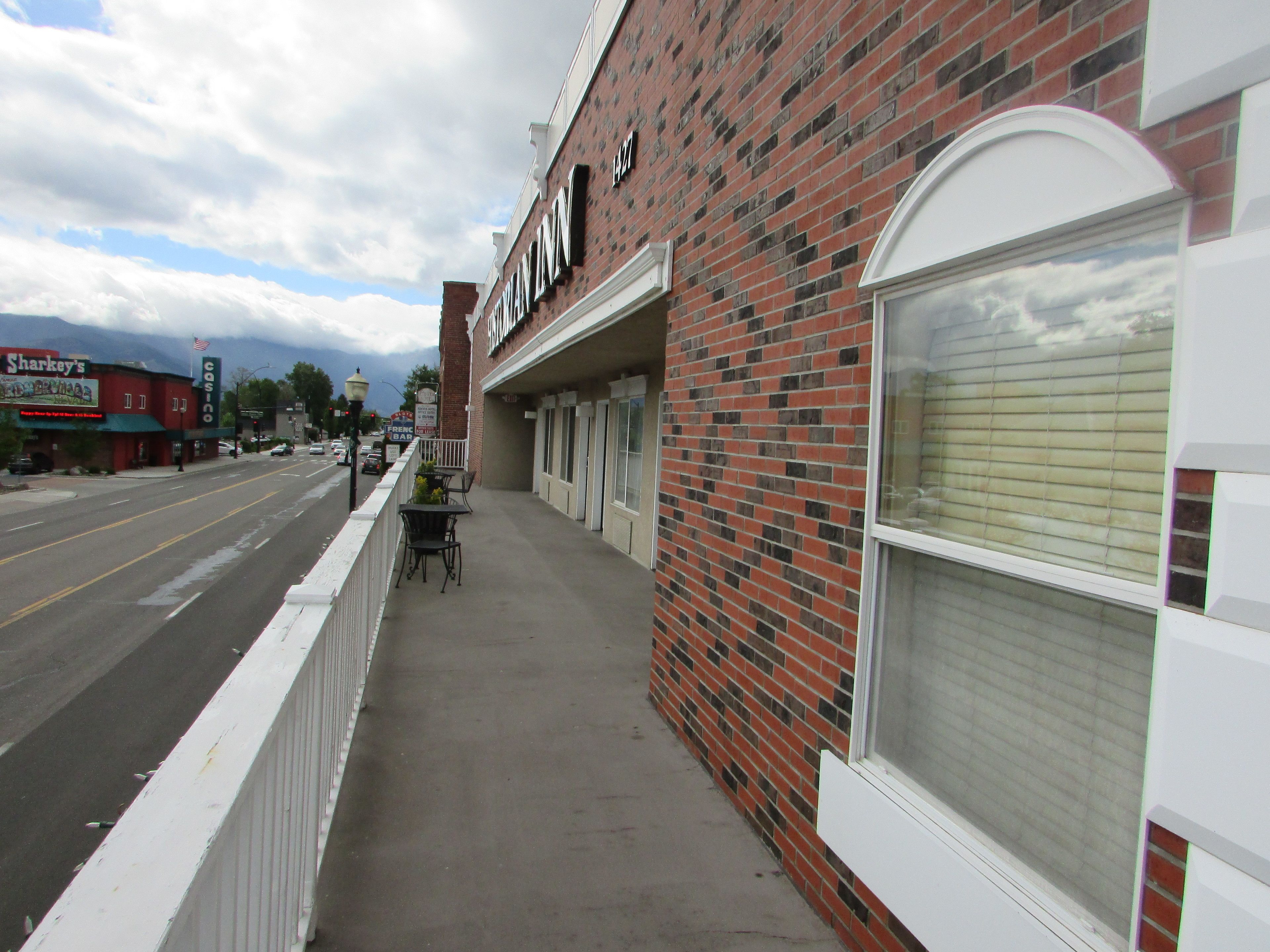 A brick building with a storefront labeled "Casino." There are outdoor tables and chairs along the sidewalk.