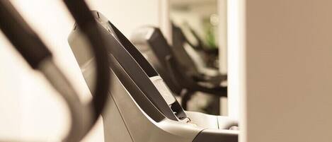 A treadmill labeled MATRIX in a gym with a wooden floor and a white wall in the background.