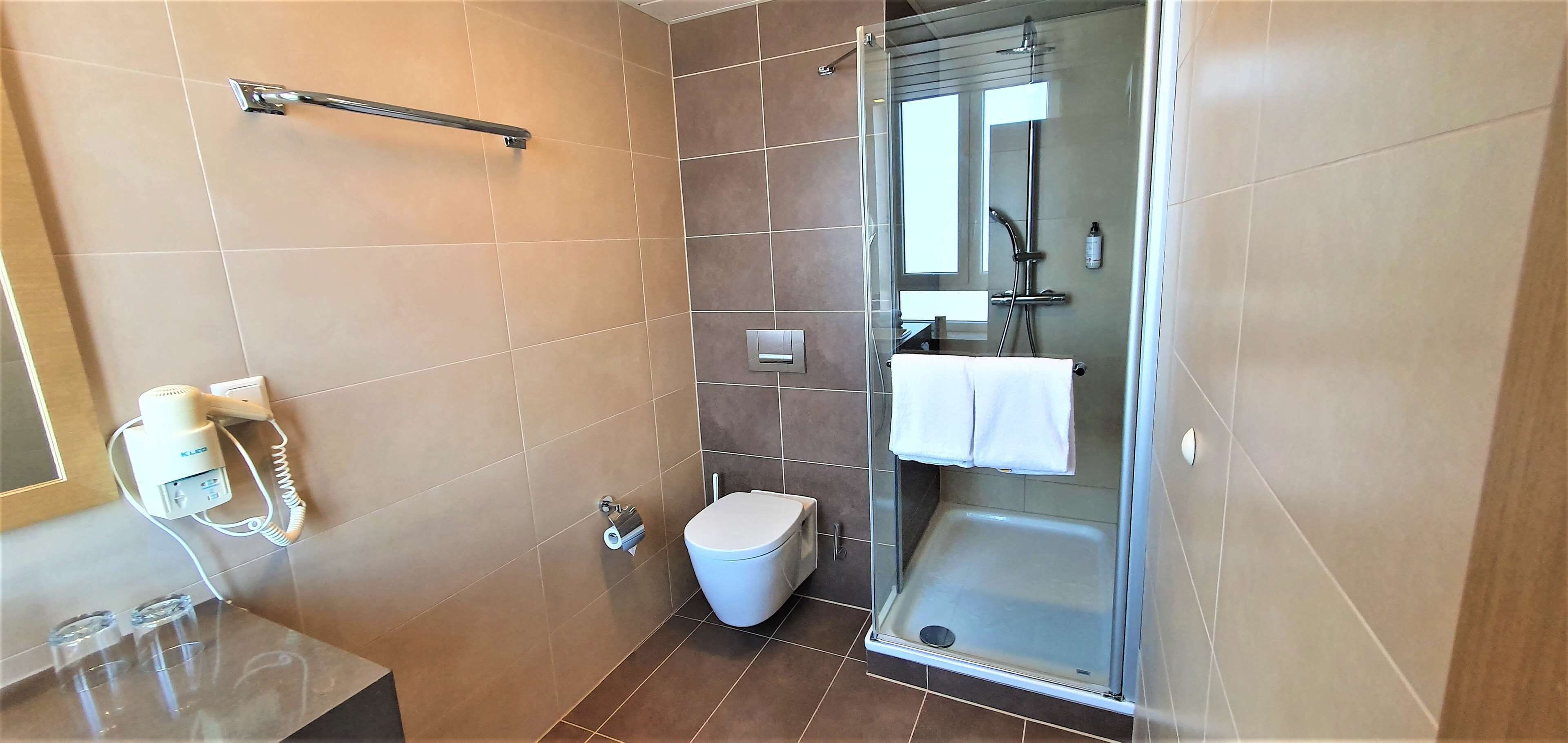 deluxe room, 1 king bed | bathroom | rainfall showerhead, eco-friendly toiletries, hair dryer, towels