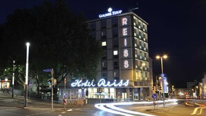 Hotel Reiss, un hotel con un letrero llamativo, situado en una glorieta con tráfico visible.