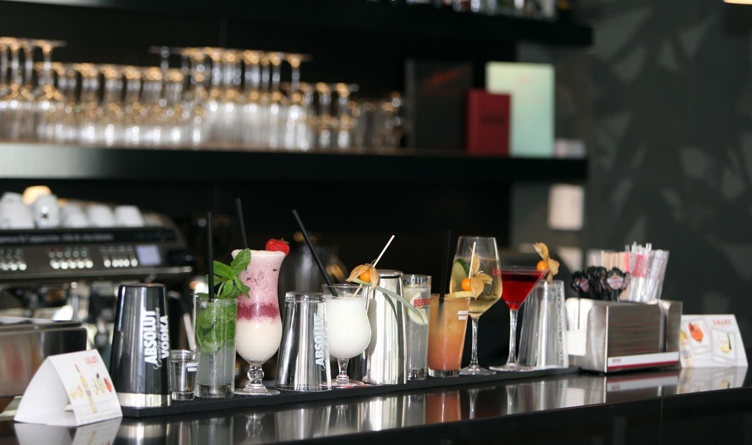 A bar area with various drinks and a bottle of Absolut vodka.