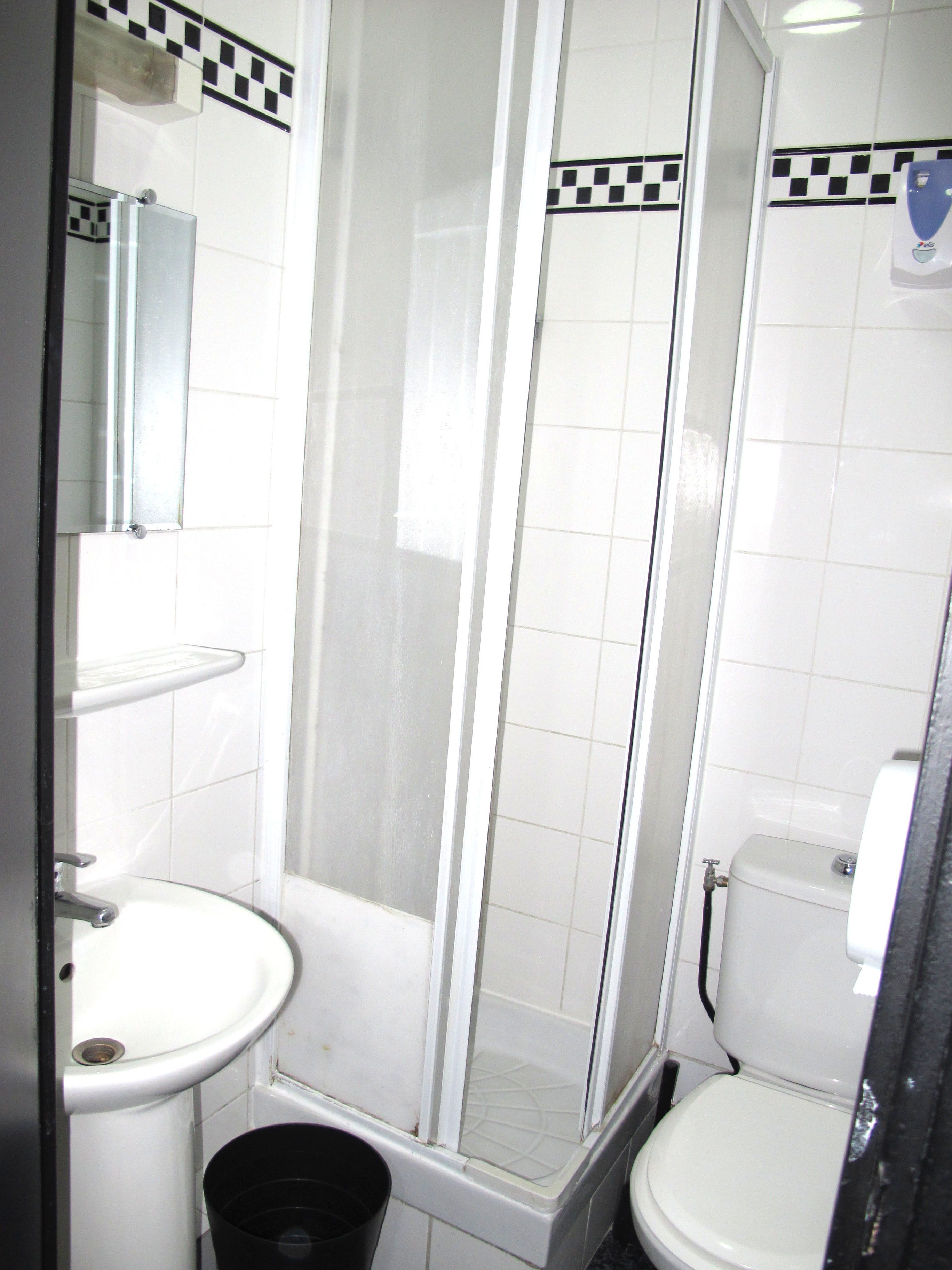 Un baño con ducha, lavabo e inodoro.