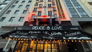 Un edificio con un cartel que dice "Peace & Love Lounge" y "Hostel", indicando un hostal y un área de lounge.