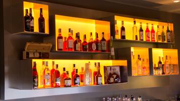A bar area with shelves of various liquor bottles and glasses.