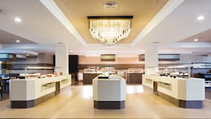 Un hall d’hôtel moderne, doté d’un lustre central, de plusieurs buffets et d’un aménagement spacieux.