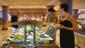 A buffet setup with various food items and waitstaff. - Hotel Riu Palace Tres Islas (La Oliva)
