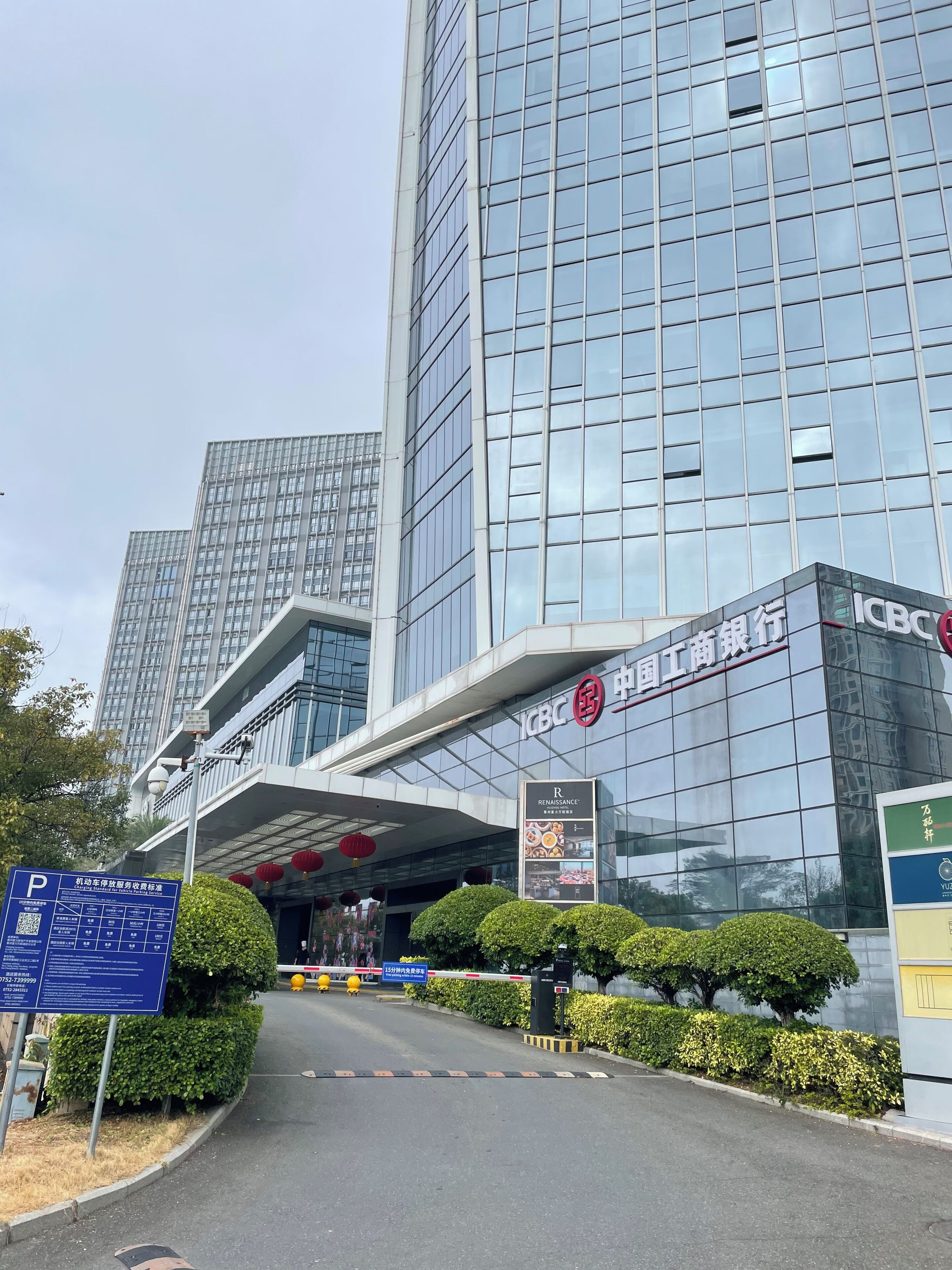 A modern building with a glass facade, signage for ICBC, and a blue parking sign.