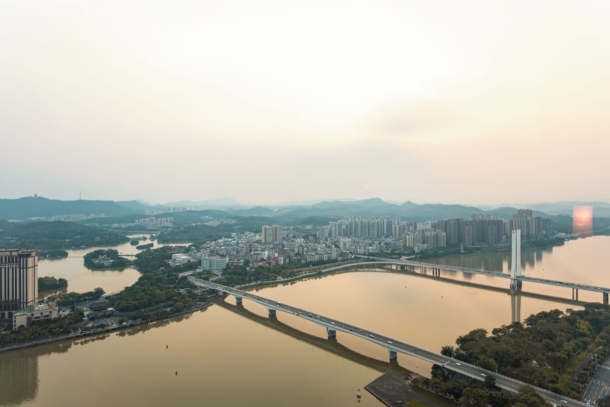 A bridge spanning a river with a cityscape in the background.