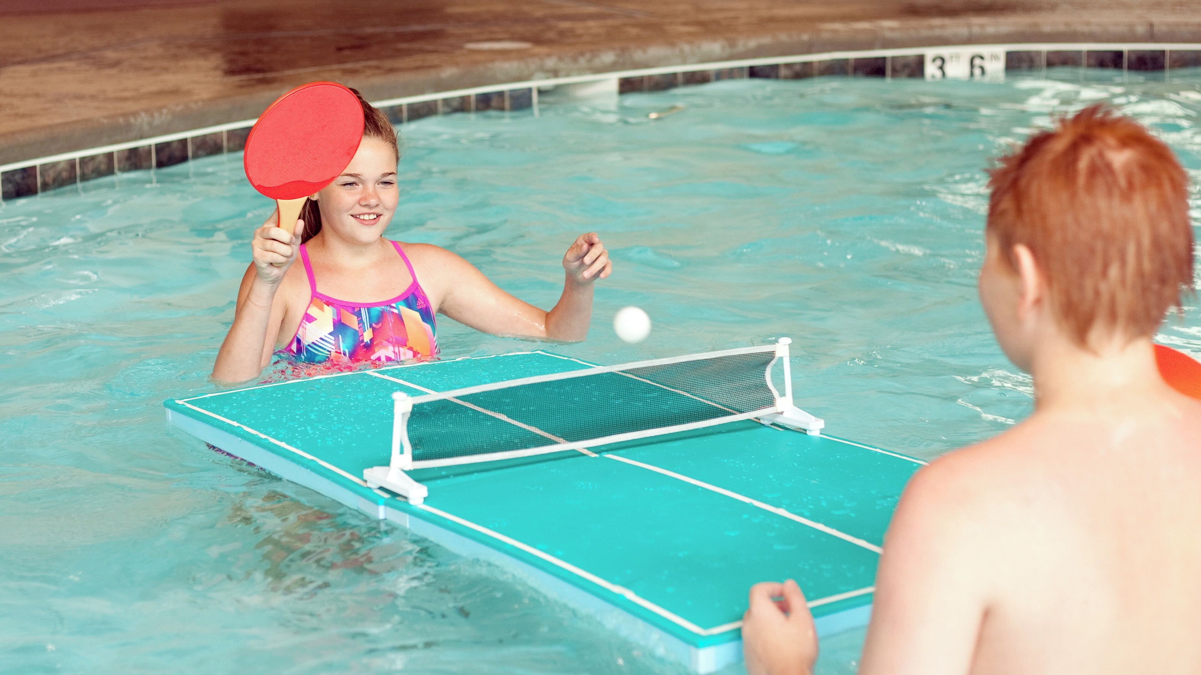 A pool table with a net in the middle of a swimming pool.