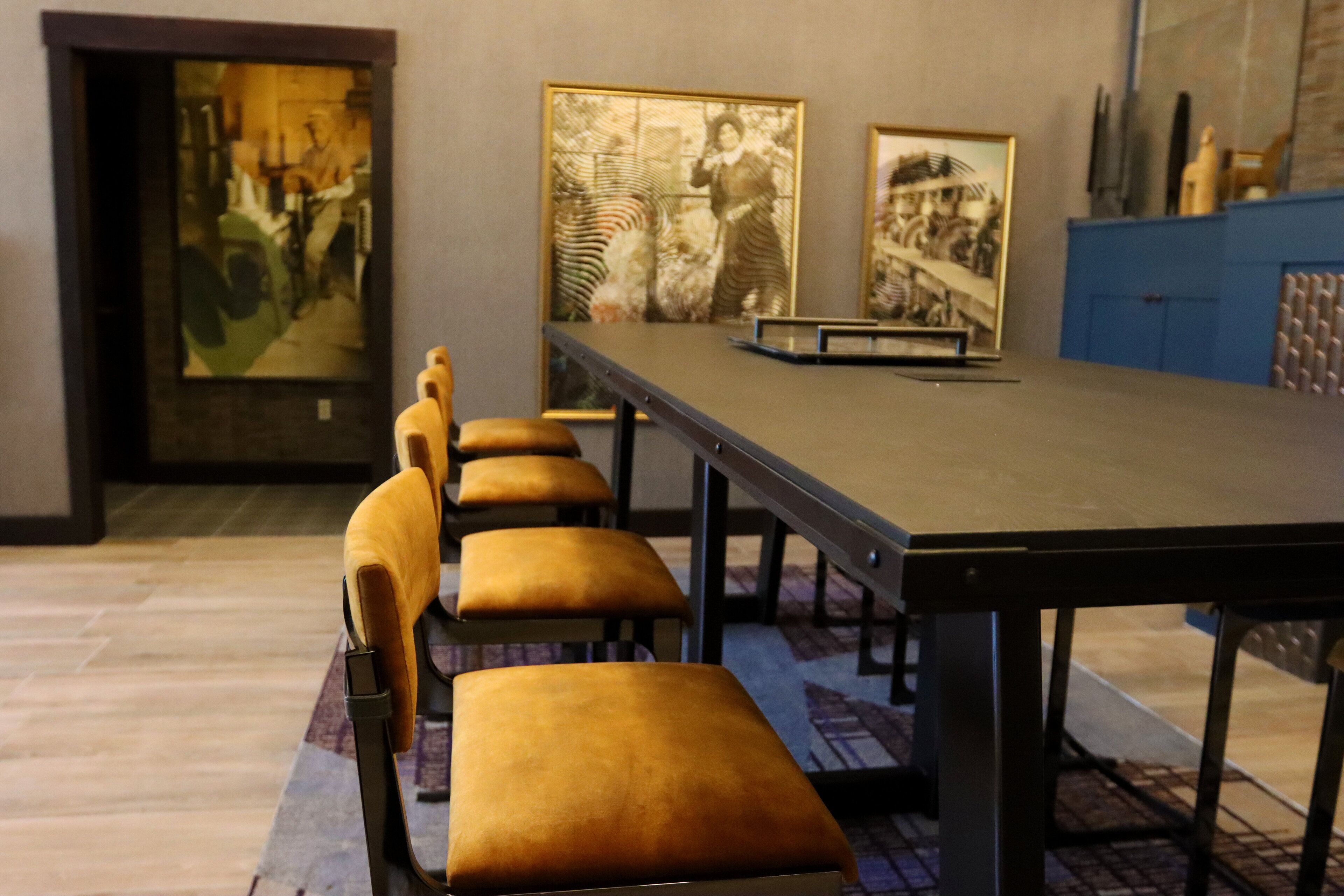Una sala conferenze con un lungo tavolo e diverse sedie con sedili imbottiti.