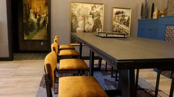 Una sala conferenze con un lungo tavolo e diverse sedie con sedili imbottiti.