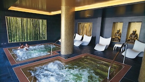 Un área de spa con dos jacuzzis, asientos y detalles decorativos.