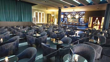 Un amplio salón con diversas opciones de asientos y un bar al fondo.
