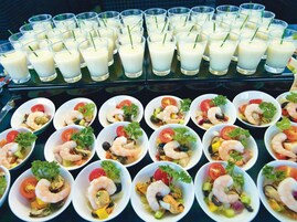 Un bufé con platos de mariscos y batidos.
