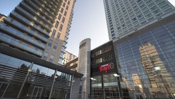 A modern high-rise building with a casino sign, surrounded by other tall buildings. - Platinum Towers Country 2 Country (Warsaw)